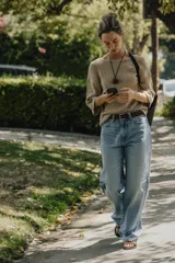 Top color beige de tejido de punto, con cuello redondo y mangas cortas tipo capa.