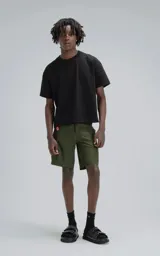 Short de baño color verde militar, confeccionado en microfibra de secado rápido. Presenta cierre frontal con cordón y velcro, y tres bolsillos con cierre (uno en cada lateral y uno trasero).