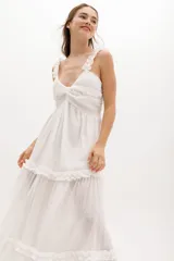 Vestido largo celeste de gasa de algodón con textura liviana. Tiene escote en V con nudo central, breteles con voladitos y frunces en la falda.