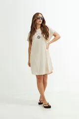 Vestido corto color beige con estampado de texto y palmeras.