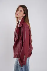 Chaqueta negra de eco-cuero, corte recto y oversize, con solapas amplias, múltiples bolsillos y cierres en las mangas.