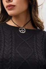 Sweater negro de tejido de punto con trenzas, corte crop y terminaciones desflecadas.