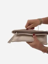 Sobre de fiesta negro charolado con cierre de solapa imantada y tira de cuero para sujetar a la muñeca.