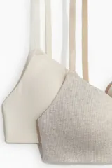 Pack de dos soutiens suaves de algodón, uno liso color blanco y otro gris con textura acanalada. Ambos con copas con relleno, breteles ajustables y cierre de corchetes en la espalda.