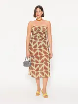 Vestido strapless confeccionado en mesh estampado con motivos geométricos color marrón sobre fondo verde lima. Lleva frunces en el delantero y cierre metálico niquelado en la espalda. Su largo llega por debajo de la rodilla.