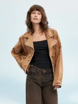 Campera color marrón claro con cuello solapa, cierre frontal con botones y bolsillos con solapa en el pecho.