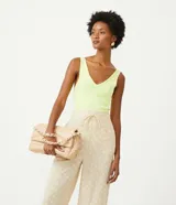 Blusa musculosa color verde lima, confeccionada en tejido de punto de viscosa sostenible, con escote en pico y sisas anchas.