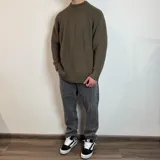 Sweater negro de tejido de punto grueso, con cuello alto y mangas raglán. Corte holgado.