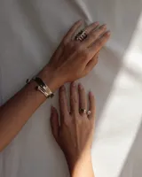 Brazalete rígido abierto de bronce con forma de herradura.