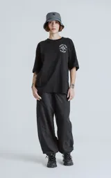 Remera negra de algodón con cuello redondo y calce oversize. Estampado en la espalda con diseño de la carta del tarot 'El Diablo', con figura femenina con cráneo de carnero sobre una pila de cráneos.