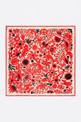 Pañuelo cuadrado de poliéster con estampado de vegetación y animales en rojo y negro sobre fondo beige.