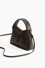 Cartera cruzada marrón con asa corta y correa extraíble.