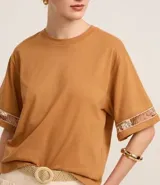 Blusa boxy de mangas cortas amplias, confeccionada en algodón, con cuello redondo y detalle de entremedios en las mangas.