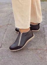 Zapatito marrón de cuero con puntera de gamuza, cierre frontal con cremallera y tirador trasero.
