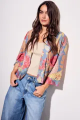 Kimono con estampado floral multicolor, mangas 3/4 y bolsillos laterales.