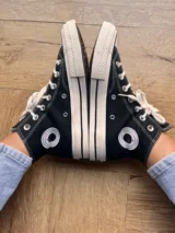 Zapatillas de lona blancas de caña alta con cordones y puntera de goma. Logo de durazno engomado en la base y en la cara interna.