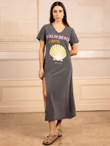Vestido largo gris con estampado de concha y texto en rosa y amarillo. Tiene escote en V, mangas cortas y tajo lateral.