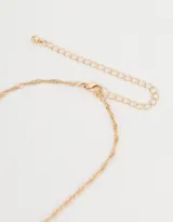 Cadena corta dorada con dije de la letra A cubierto de strass.