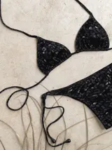 Conjunto de bikini con corpiño de triángulos movibles con tiras finas para atar al cuello y a la espalda. Incluye bombacha vedetina con tiras finas a los costados para atar.