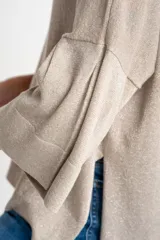 Sweater color cobre brillante, de tejido de punto con lurex, corte oversize, cuello redondo y mangas 3/4 con volados.