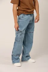 Pantalón de jean celeste, corte holgado, con bolsillos cargo laterales y costuras frontales.