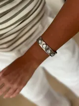Pulsera rígida plateada con incrustaciones de nácar.