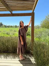 Vestido largo color beige, de corte amplio, con mangas cortas abullonadas y volado en el ruedo.