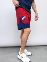 Bermuda de entrenamiento color rojo con detalles en azul, con escudo del Club Nacional de Football estampado en la pierna derecha.
