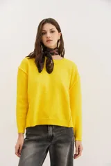 Sweater amarillo de punto con cuello redondo y mangas largas.
