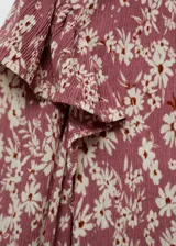 Blusa de manga larga con estampado floral en tonos rosa y blanco, escote en V, volantes en los hombros y puños elásticos.