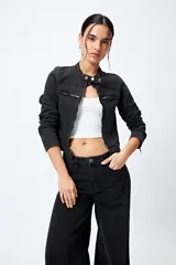 Campera entallada de denim con estampado animal print de cebra en tonos beige y negro. Tiene cuello mao con broches metálicos, cierre frontal con cremallera, bolsillos con cierre en el pecho y mangas largas con puños con cierre.