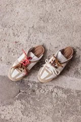 Zuecos color tostado de cuero con cordones de colores.