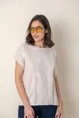 Blusa italiana color celeste con bordado de plumas al tono en el frente, confeccionada en lino y algodón.