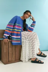 Cardigan azul con rayas horizontales en tonos rosa, naranja, blanco y verde.