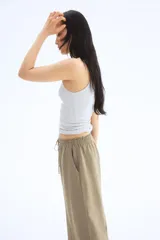 Pantalón de corte holgado color arena, confeccionado en tejido liviano de mezcla de lino. Modelo de tiro alto con elástico revestido en la cintura, cordón para ajustar fino y piernas amplias con bolsillos al bies.