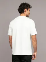 Remera blanca de algodón con logo de Calvin Klein texturizado en el pecho. Corte regular fit, manga corta y cuello redondo.