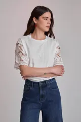 Remera blanca de algodón con mangas cortas de encaje floral.