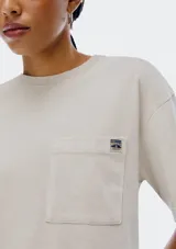 Remera color beige de corte recto, con cuello redondo y bolsillo en el pecho.