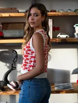 Chaleco tejido blanco con estampado floral rojo, escote en V y cierre frontal con botones.