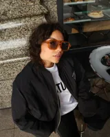 Lentes de sol unisex con montura cuadrada color naranja y cristales grises.