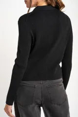 Cardigan negro de tejido de punto acanalado, con cuello polo, corte al cuerpo y cierre frontal con botones.