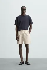 Bermuda de algodón color marrón oscuro, de corte regular fit, con cintura elástica ajustable mediante cordón. Presenta bolsillos laterales y un bolsillo trasero de vivo.