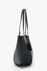 Bolso de hombro tipo shopper color beige, con doble asa y cierre imantado. Incluye una cartera interior con cierre de cremallera.