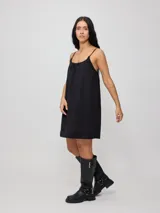 Vestido corto de algodón y lino color negro, con tirantes finos y escote recto con lazo ajustable.