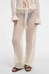 Pantalón de crochet color blanco, de tiro alto y corte acampanado.