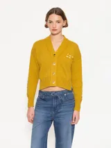Cardigan corto color mostaza, tejido en hilado de lino combinado con algodón grueso. Incluye bordado a tono Jch.