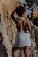 Minifalda celeste de lino y poliéster, con corte cruzado y lazo lateral.