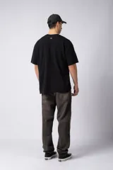 Remera color crudo de corte oversize, con cuello redondo y mangas cortas. Presenta un pequeño bordado de un sol en el centro del pecho.