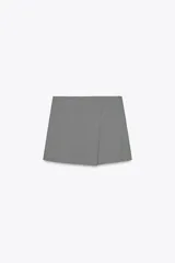 Falda pantalón corta de tiro alto con estampado pata de gallo, corte cruzado y cierre lateral con cremallera oculta.