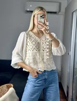 Camisa color crema con detalles de encaje y mangas largas abullonadas de gasa.